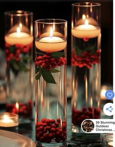 candles in glass vases filled with red berries and greenery