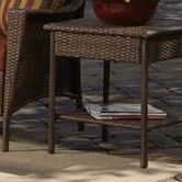 a table that has some books on it next to a chair and potted plant