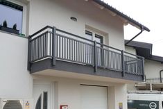 a white van is parked in front of a building with a balcony and balconies