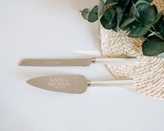 two knives sitting on top of a white table next to a potted green plant