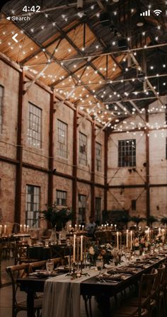 an indoor venue with long tables and lights hanging from the ceiling