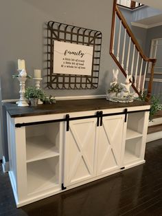 a white cabinet with sliding doors on the front and side, next to a staircase