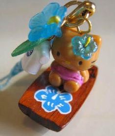 a keychain with a bear on top of it and flowers in the back