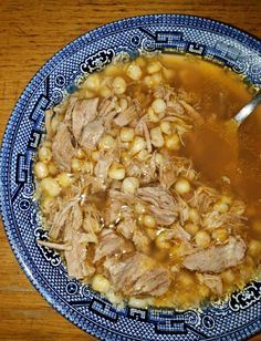 a bowl filled with meat and chickpeas soup on top of a wooden table