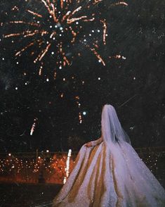 a bride looking at fireworks in the sky