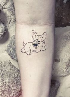 a small tattoo of a dog holding a coffee cup in its mouth on the ankle