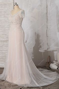 a wedding dress on display in front of a white brick wall with an open back