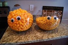 two glass bowls filled with corn and eyes on top of a countertop next to each other