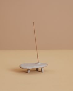 a small white object with a wooden stick sticking out of it's center piece