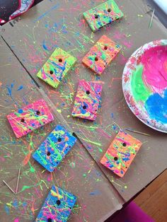 the paper plate is next to some crafting supplies on the table with colorful paint