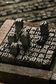 an old wooden board game with chinese characters on it's sides and dices in the middle