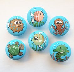 six blue buttons with sea animals painted on them