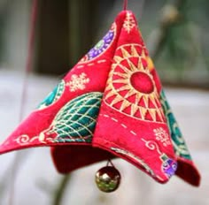 a red and green bell hanging from a string