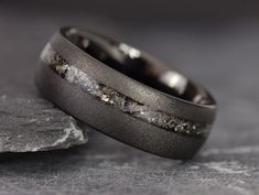 two wedding bands with white and black diamond inlays on top of each other