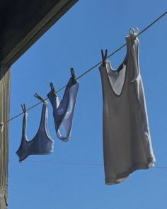 two bras hanging on a clothes line with blue sky in the background