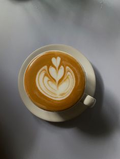 a cappuccino on a saucer with white swirls in the foam