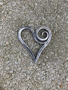 a heart shaped metal object sitting on the ground