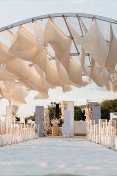 an outdoor ceremony with white draping and candles