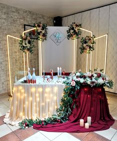 the table is set up with candles, flowers and greenery for an elegant wedding reception