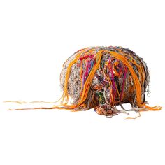 a ball of yarn is laying on the ground with its tail curled up to it's side