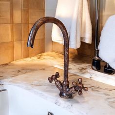 a faucet that is sitting on top of a sink in a bathroom next to towels