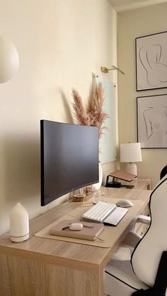 a computer desk with a monitor, keyboard and mouse on it in front of a window