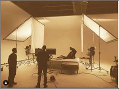 three people in a studio setting with lighting equipment