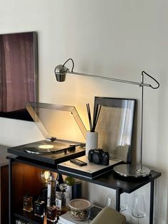 a record player sitting on top of a table next to a lamp and other items