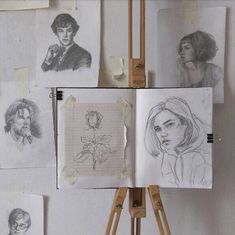 several drawings are displayed on an easel