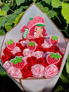 a bouquet of strawberries and roses in a paper wrapper with a strawberry on top