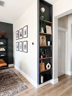 a living room filled with lots of furniture and pictures on the wall next to a doorway