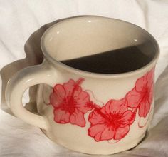 a coffee cup with red flowers painted on it