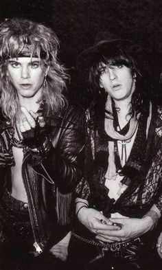 two women with long hair and leather jackets posing for a photo in black and white