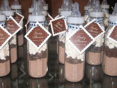 there are many baby shower bottles with labels on the top one is filled with chocolate and marshmallows