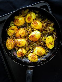 some food is cooking in a skillet on the stove top and ready to be eaten