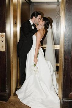 a bride and groom kissing in an elevator