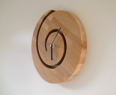 a wooden clock mounted to the side of a wall with a circular design on it