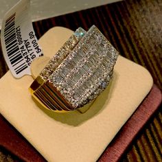 a large diamond ring sitting on top of a wooden table next to a roll of paper