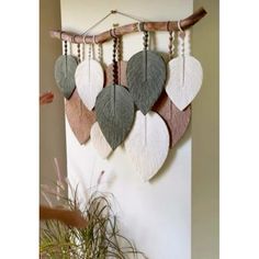 a wall hanging made out of wood and leather with leaves attached to the back of it