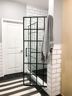 a towel is hanging on a rack in a bathroom with black and white floor tiles