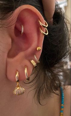 a woman with ear piercings on top of her head and behind her ear is an earring