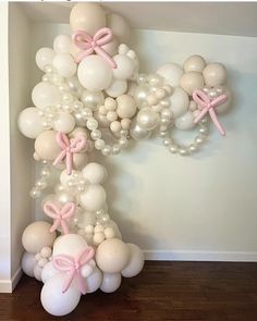 balloons and bows are arranged in the shape of an x on top of a wall