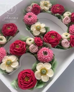 a number made out of cupcakes with pink and white flowers on them in a box