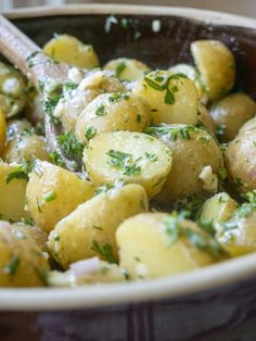 a close up of a bowl of food with broccoli and potatoes in it