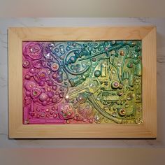 an abstract painting with water droplets on it in a wooden frame hanging on the wall