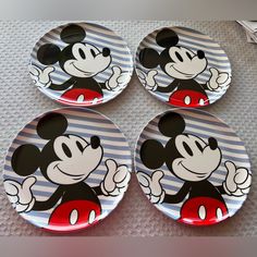 four mickey mouse plates sitting on top of a table