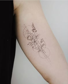 a woman's arm with a flower tattoo on the left side of her arm