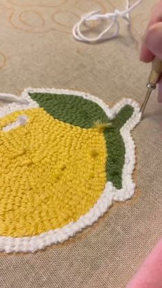 someone is crocheting a lemon rug on the floor