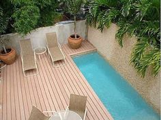 an outdoor patio with table and chairs next to a pool