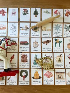 a wooden table topped with christmas cards and a toy horse on top of it's back